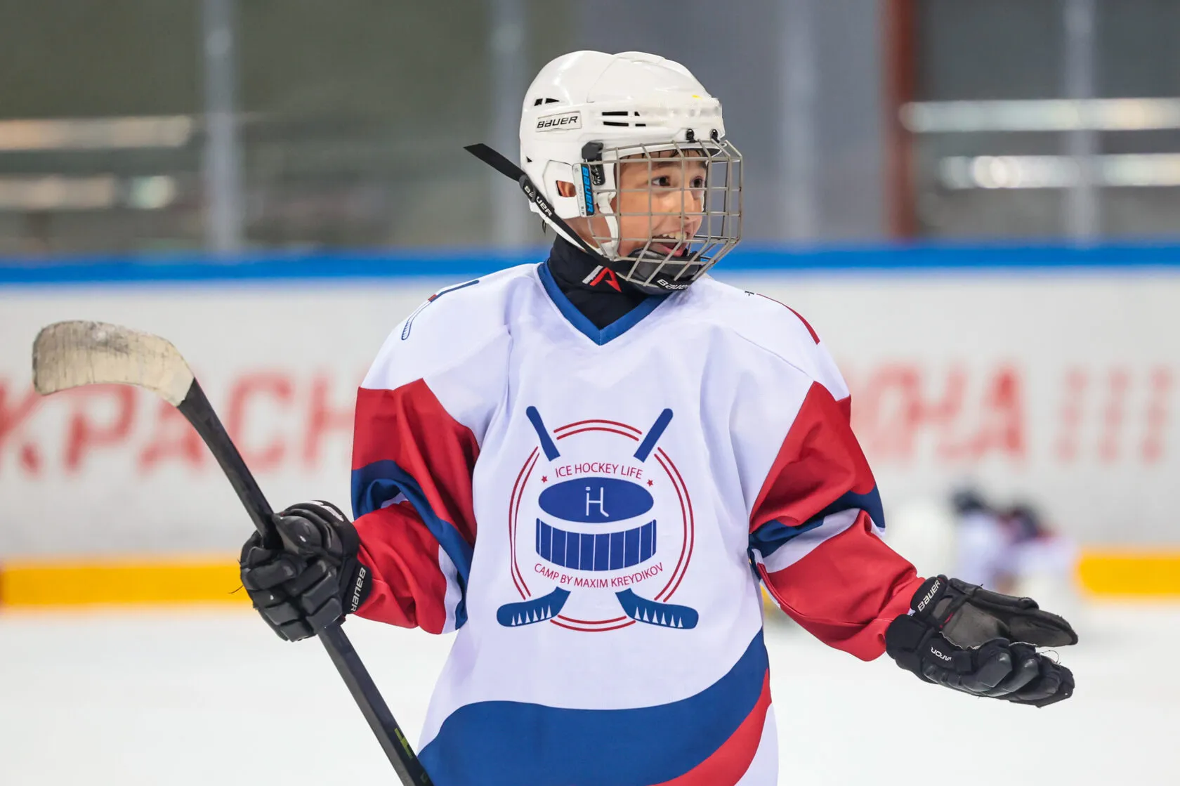 Улыбающийся мальчик в шлеме и джерси с эмблемой Ice Hockey Life